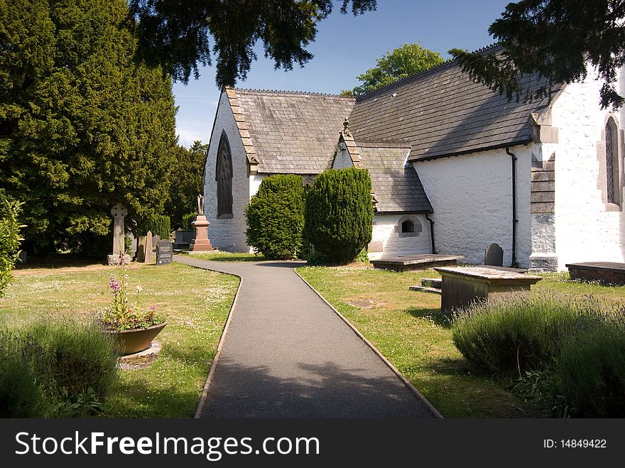 A country church in wooded grounds, against blue skies