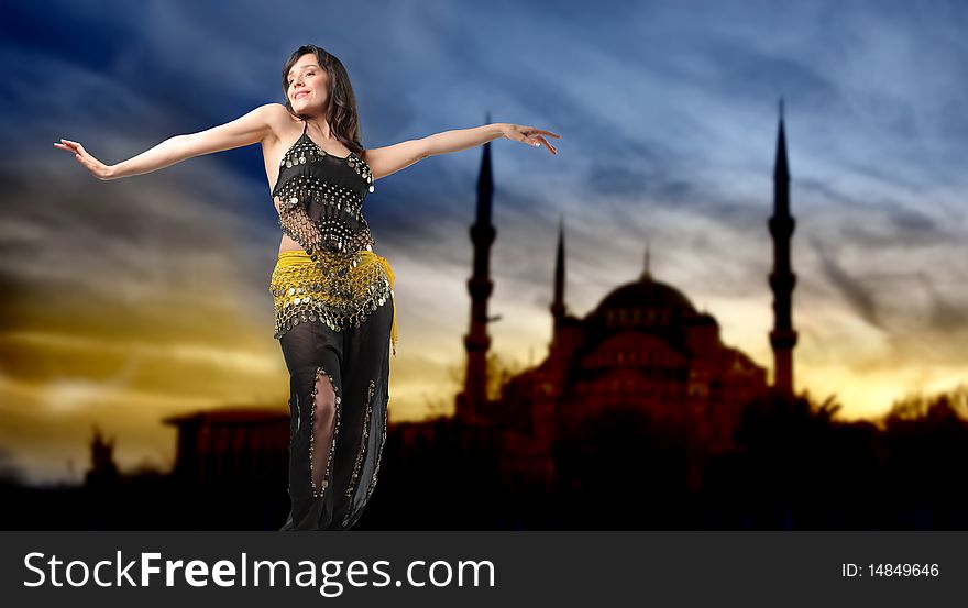 Portrait of a beautiful woman in arabic clothes dancing with mosque on the background. Portrait of a beautiful woman in arabic clothes dancing with mosque on the background