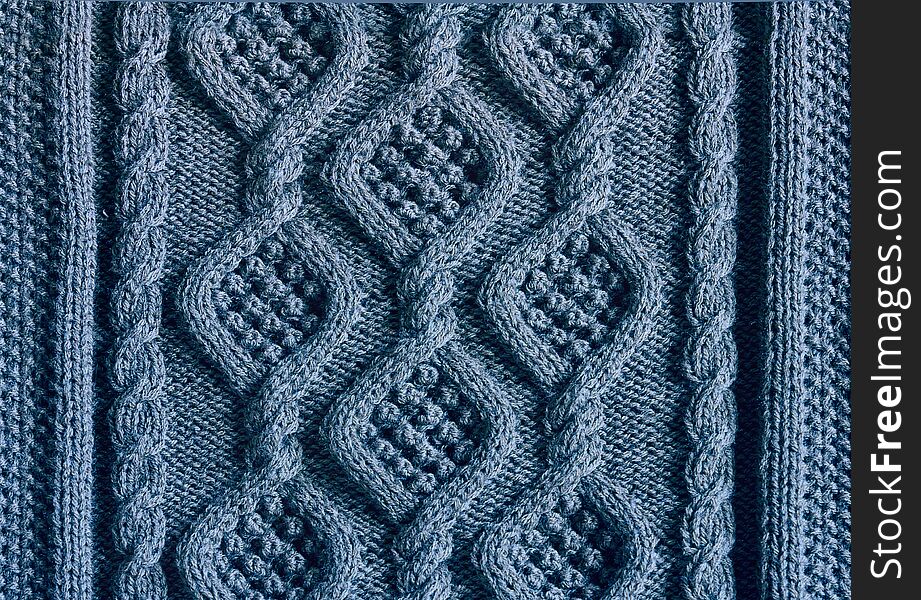 Background texture knitted canvas with patterns Aran closeup blue color