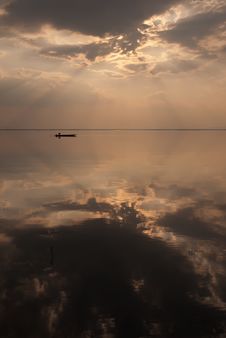 Silhouette Of A Small Boat On Mirror-reflected Dam Stock Image