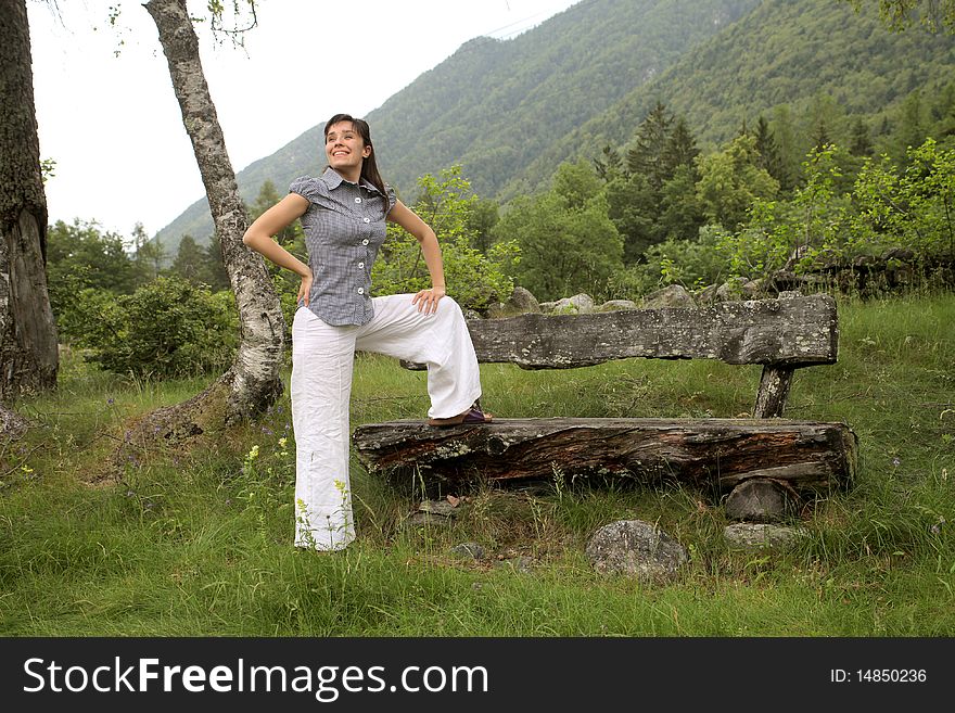 Smiling woman standing in a wood at the mountain