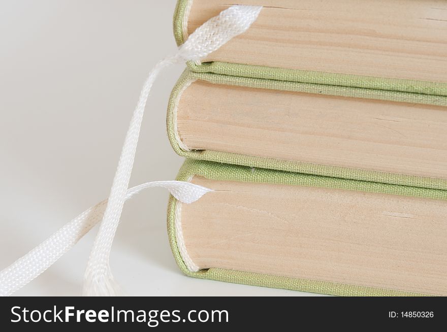 Pile of hardcover books with white bookmarks