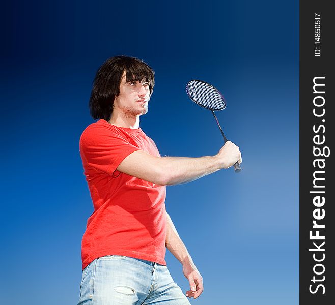 Boy in jeans with racket on blue background. Boy in jeans with racket on blue background
