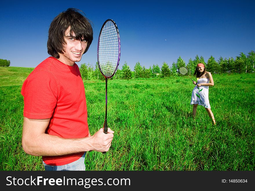 Girl and smiling boy with rackets on field. Girl and smiling boy with rackets on field