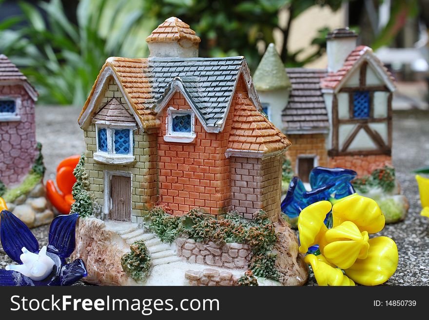 Picture of miniature houses surrounded by glass flowers.