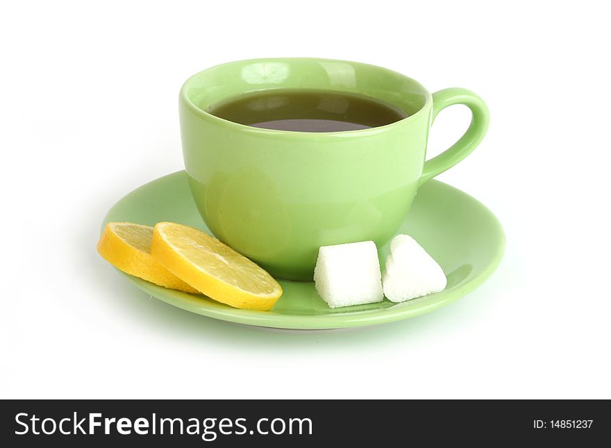 Cup of tea with lemons and lumps of sugar on white background