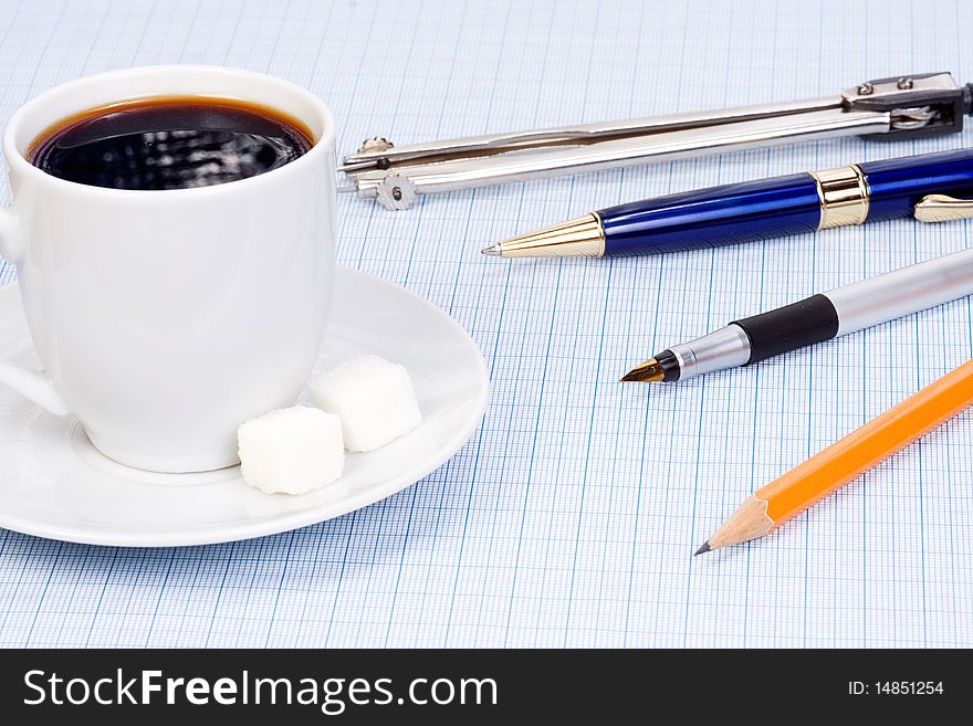 Coffee and pens at paper