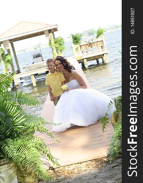 Shot of a beautiful bride with child on dock