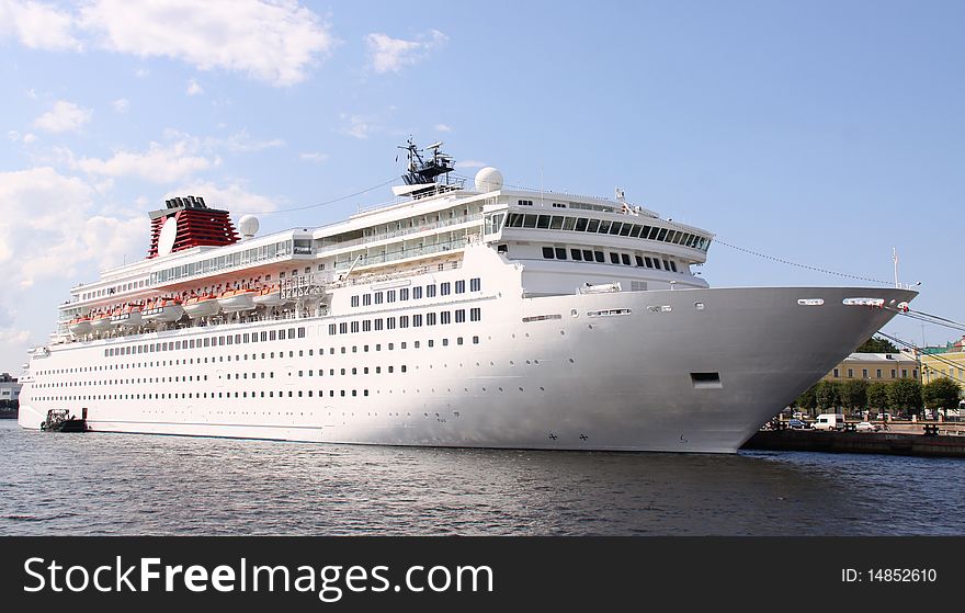 Luxury white cruise ship shot at angle at water level on a clear day with calm seas and blue sky