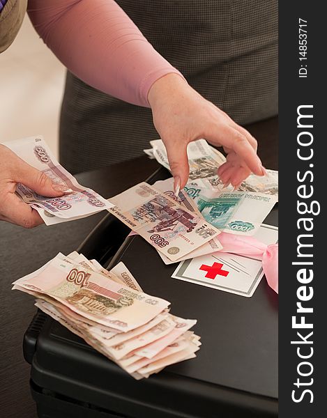 The first-aid set with a red cross and female hands counting money. The first-aid set with a red cross and female hands counting money.