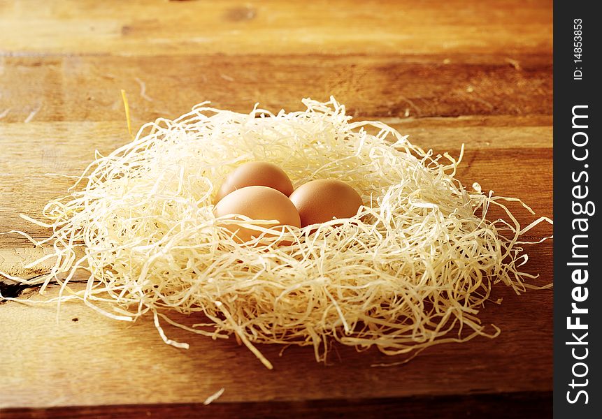 Eggs in a nest on a wooden table. Eggs in a nest on a wooden table