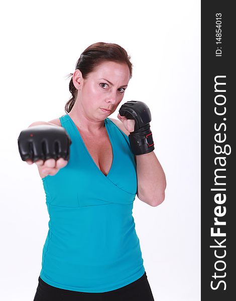 A woman stands with mixed martial arts gloves and throwing a punch. A woman stands with mixed martial arts gloves and throwing a punch.