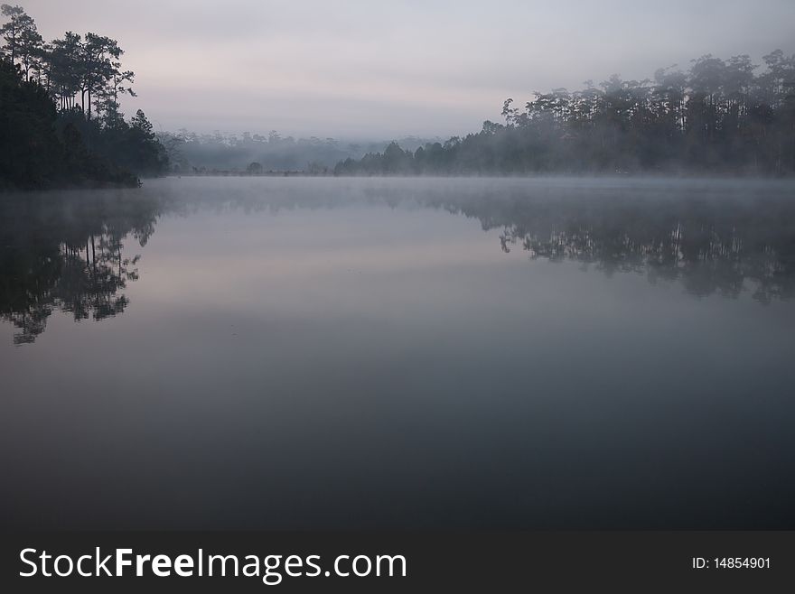 Morning mist reflects from flat lake in northern Thailand. Morning mist reflects from flat lake in northern Thailand