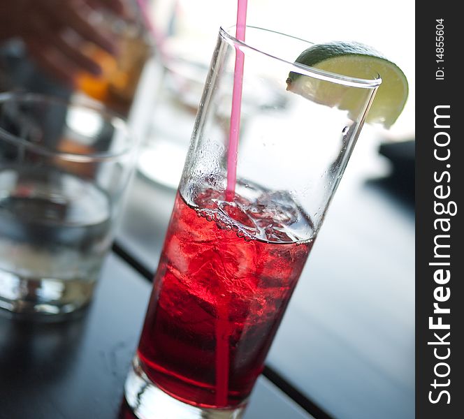 Cranberry juice with straw and lime at restaurant. Cranberry juice with straw and lime at restaurant