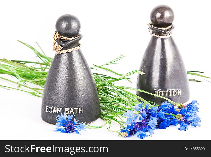 Foam bath and lotion with cornflowers on white