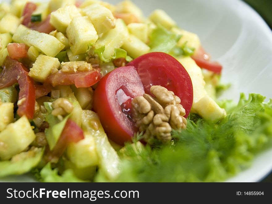 Delicious salad with fresh raw vegetables. Salad is made of: zucchini, walnuts, tomato, cucumber, lettuce leaves, turmeric, salt, oil from walnuts. Delicious salad with fresh raw vegetables. Salad is made of: zucchini, walnuts, tomato, cucumber, lettuce leaves, turmeric, salt, oil from walnuts.