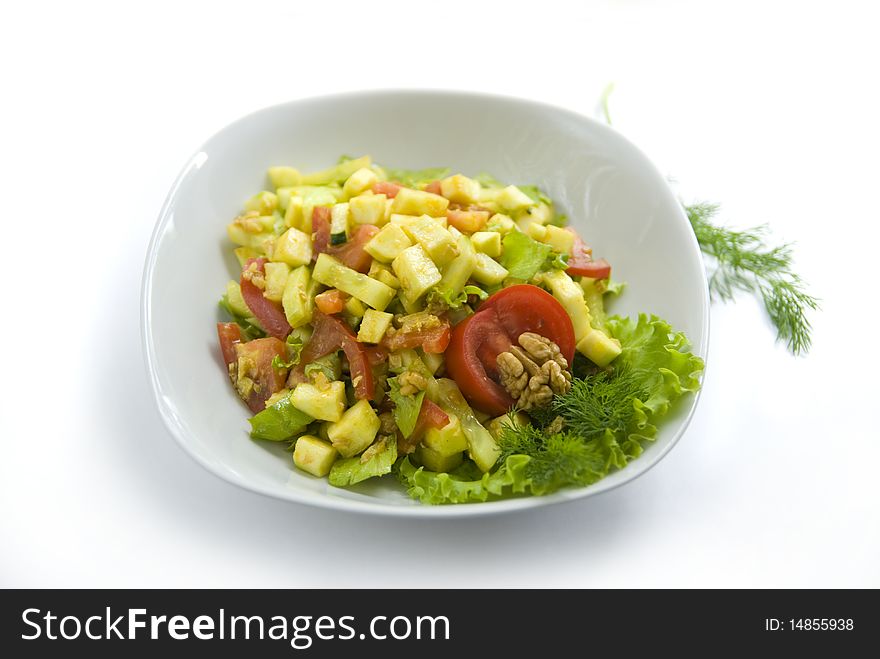 Delicious salad with fresh raw vegetables. Salad is made of: zucchini, walnuts, tomato, cucumber, lettuce leaves, turmeric, salt, oil from walnuts. Delicious salad with fresh raw vegetables. Salad is made of: zucchini, walnuts, tomato, cucumber, lettuce leaves, turmeric, salt, oil from walnuts.