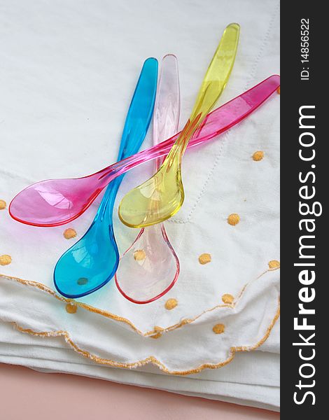 A colorful plastic spoons on a white kitchen towel