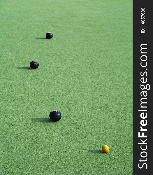 Four bowl balls, three black and one yellow