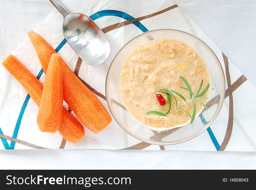 Ginger and carrot creamy soup in a glass bowl