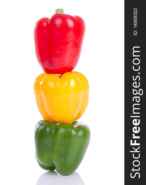 Photograph showing yellow,green and red peppers stacked isolated