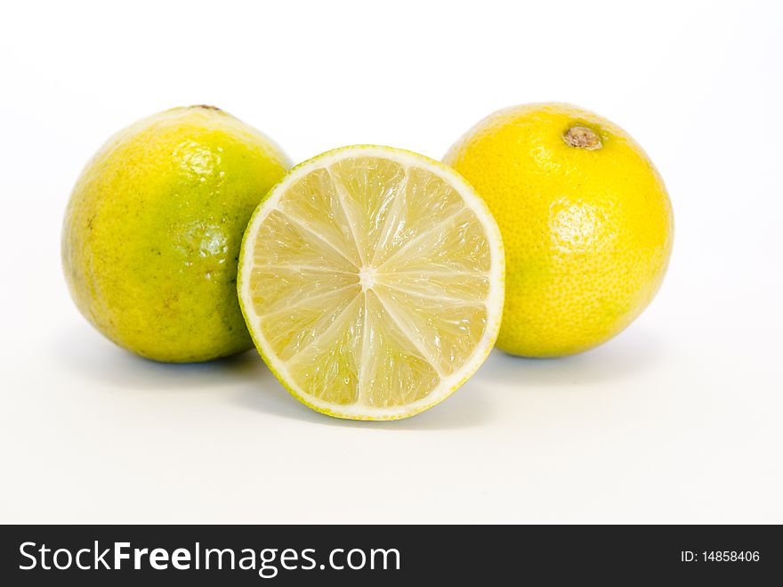 Fresh lemons in the foreground on white background