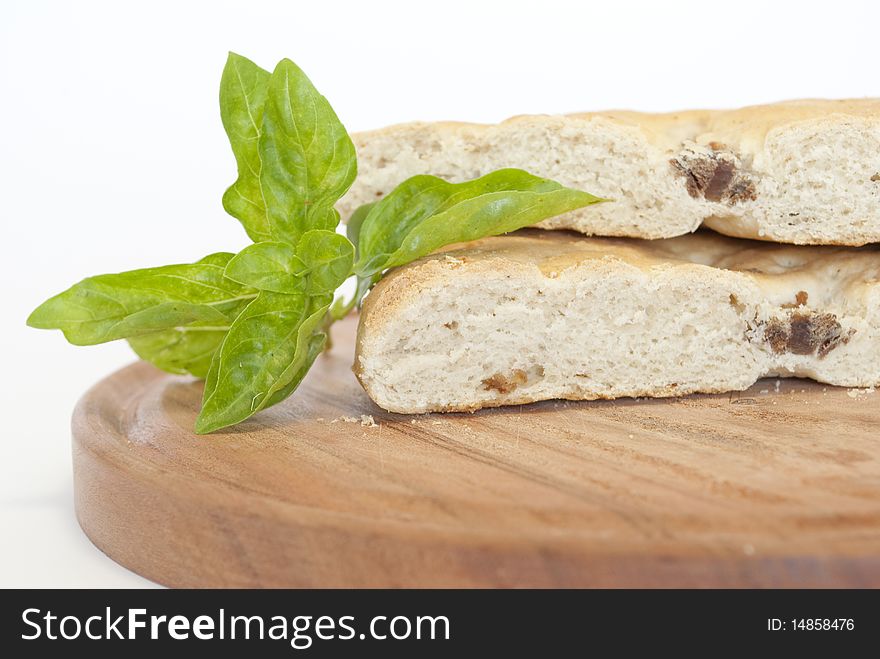 Pigskin bread and basil leaves in the foreground. Pigskin bread and basil leaves in the foreground