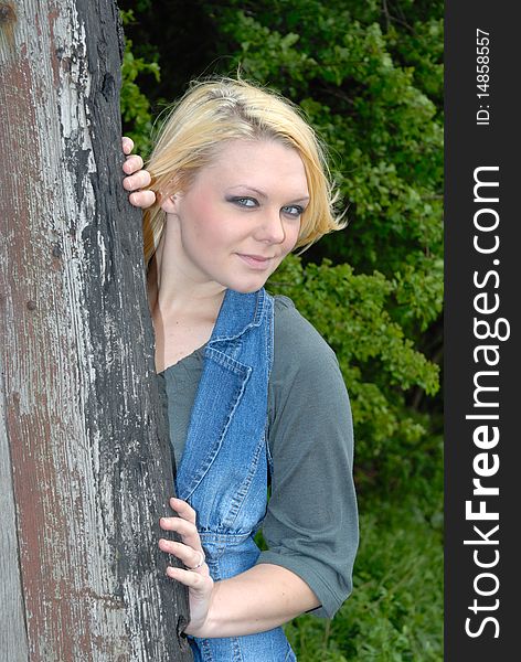 Photograph of pretty blond girl posing against tree. Photograph of pretty blond girl posing against tree