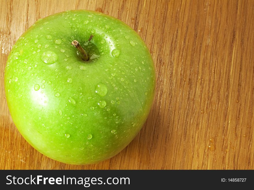 Green apple covered in dew on the kitchen table. Green apple covered in dew on the kitchen table