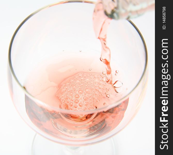 Pink wine being poured into a wine glass