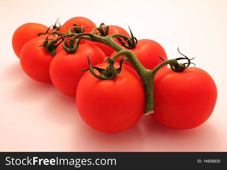 Fresh tomatos with green branch on white background. Fresh tomatos with green branch on white background.