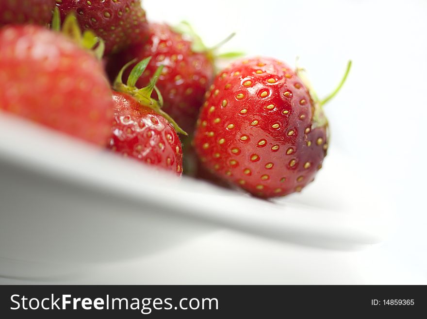 Juicy, ripe strawberries on a plate with white background