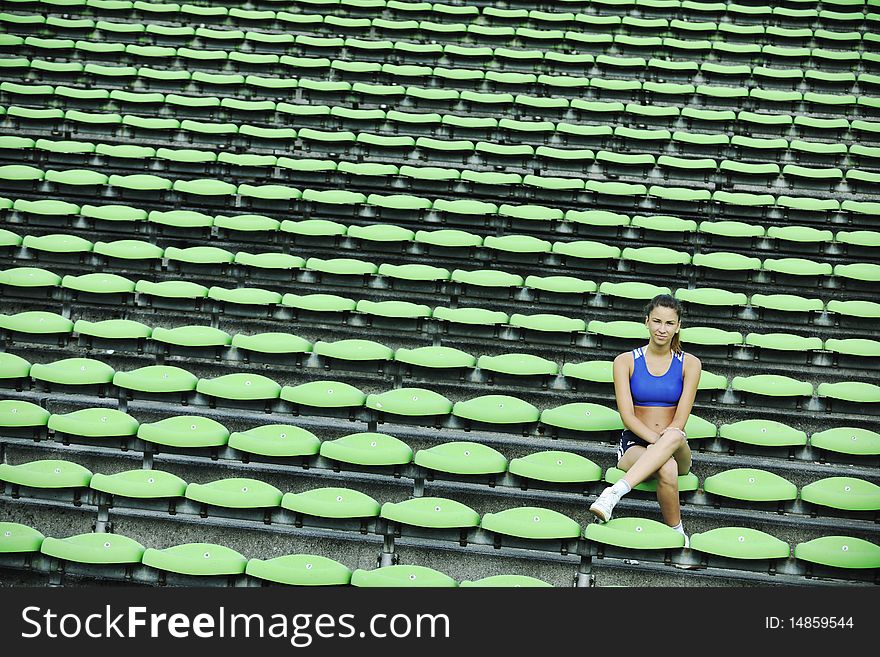 Happy young woman streching at athletics stadium and relax. Happy young woman streching at athletics stadium and relax