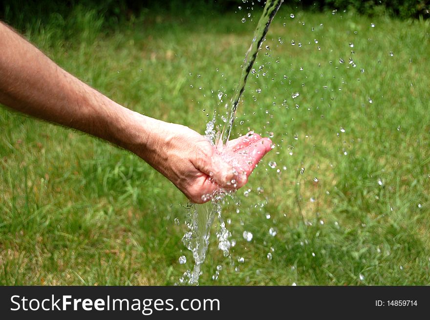 Water splashing out of a man's cupped hand. Water splashing out of a man's cupped hand