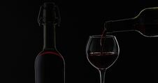 Rose Wine. Red Wine Pour In Wine Glass Over Black Background. Silhouette Stock Photos