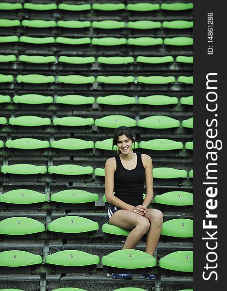 Happy young woman streching at athletics stadium and relax. Happy young woman streching at athletics stadium and relax