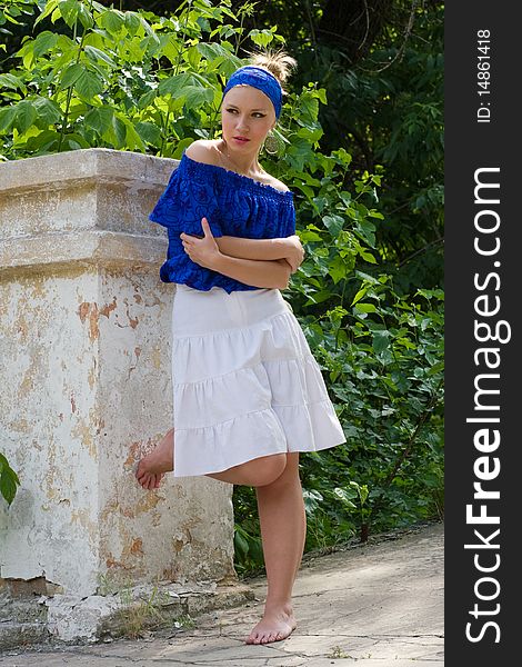 Pretty young woman in blue blouse and white skirt outdoors. Pretty young woman in blue blouse and white skirt outdoors
