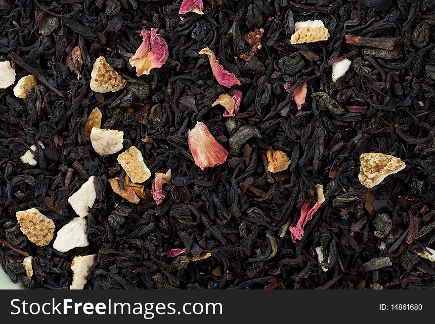 Black tea with petals of colours. A background. Black tea with petals of colours. A background