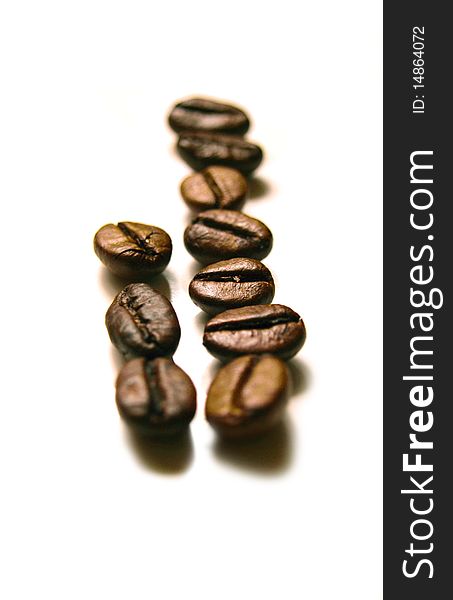 Fragrant fried ripe black coffee in grains on a white background