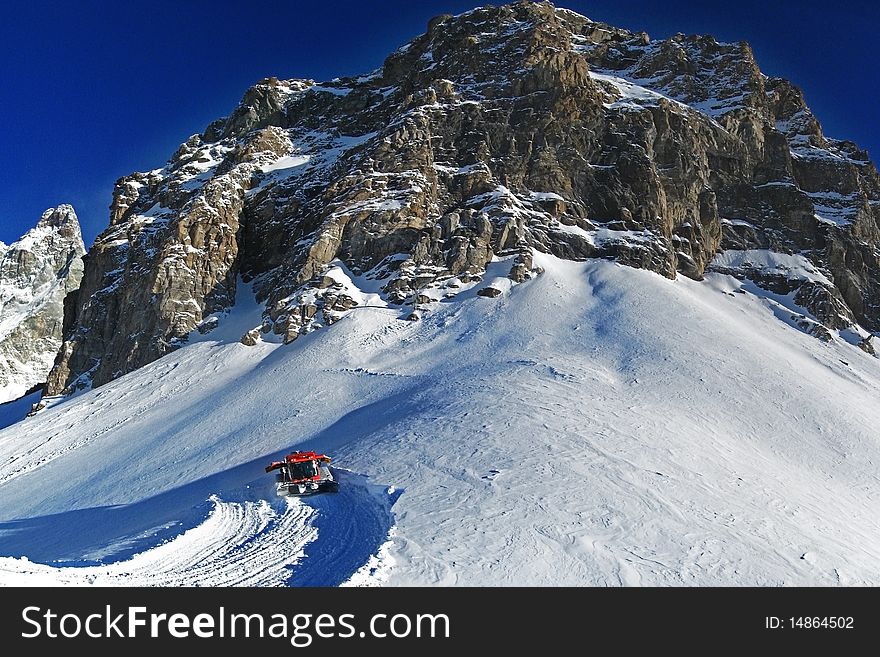 Red snowcat working on european alps. Red snowcat working on european alps