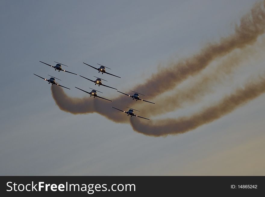 Canadian Snowbirds jet aerobatic team flying CT-114 tutor jet airplanes at sunset