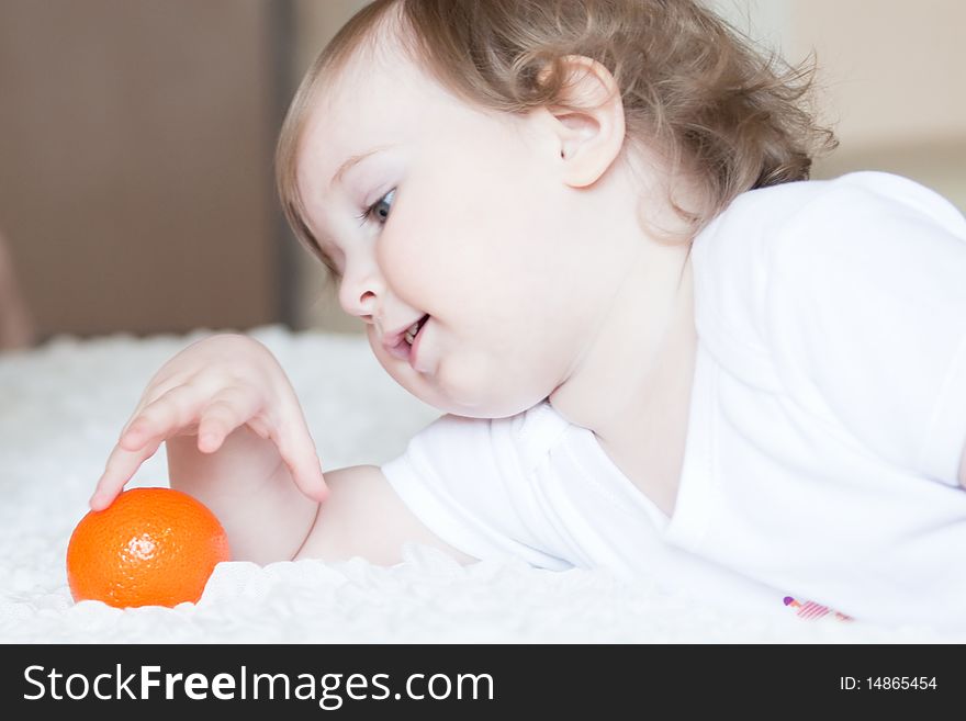 Little cute girl playing with fresh tangerine. Little cute girl playing with fresh tangerine