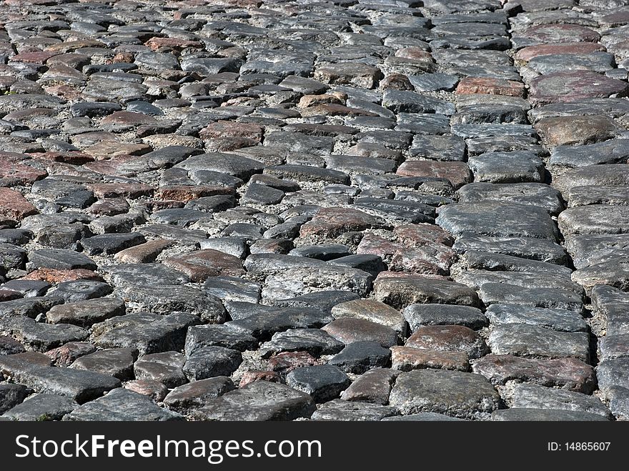 Cobbled road close-up; texture; background. Cobbled road close-up; texture; background