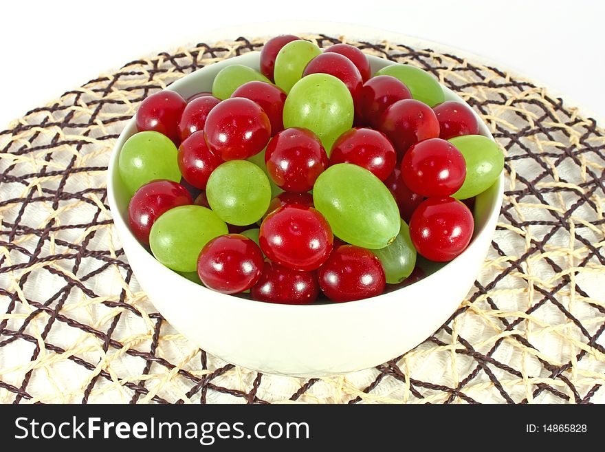 Sour cherry and grape in white bowl