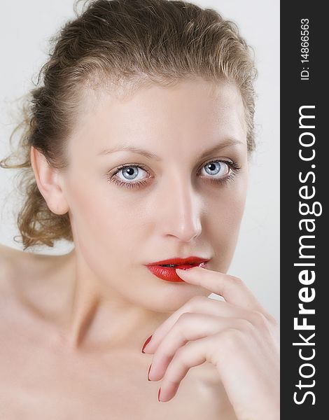 Close-up portrait of young woman with blue eyes, red bright manicure and lips. Close-up portrait of young woman with blue eyes, red bright manicure and lips