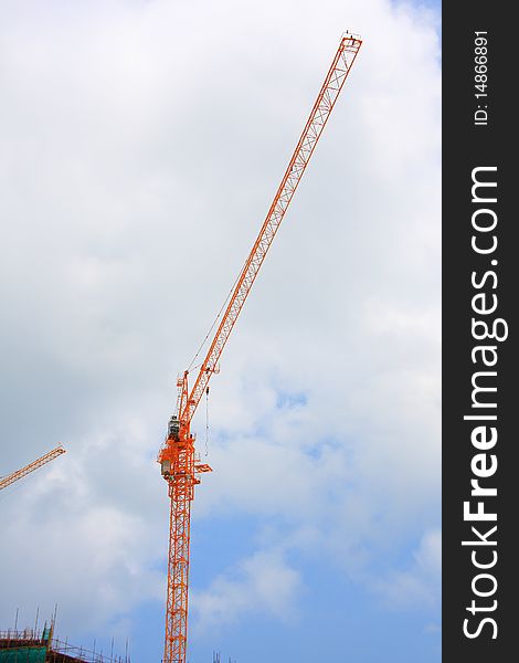 Cranes on a construction site with blue sky.