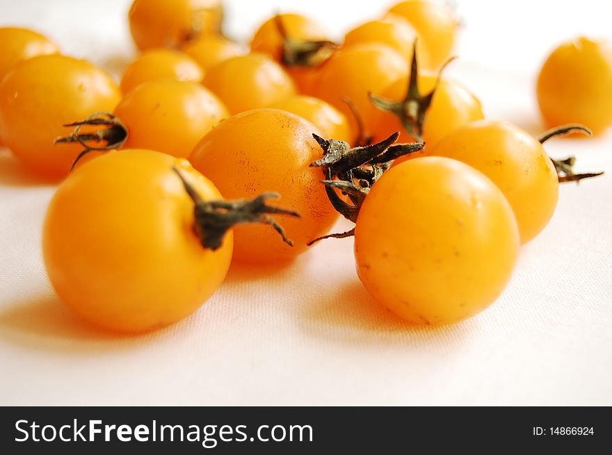 Yellow cherry tomatoes on white background. Yellow cherry tomatoes on white background