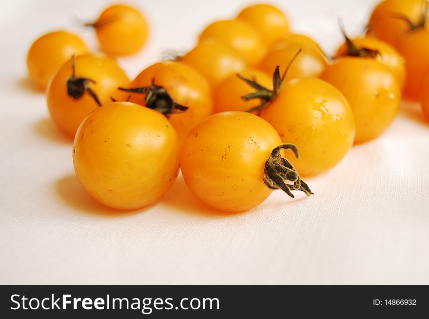 Yellow cherry tomatoes on white background. Yellow cherry tomatoes on white background
