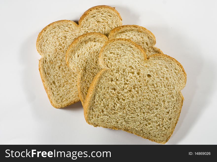 Three slices of wheat bread against a white background. Three slices of wheat bread against a white background