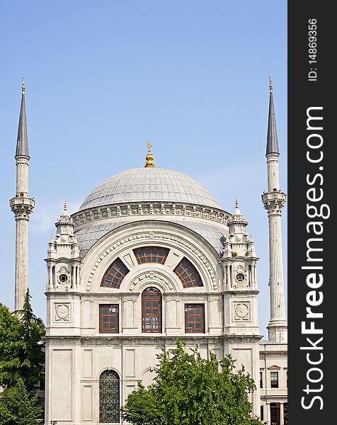 A small ornate mosque against a blue sky background. A small ornate mosque against a blue sky background